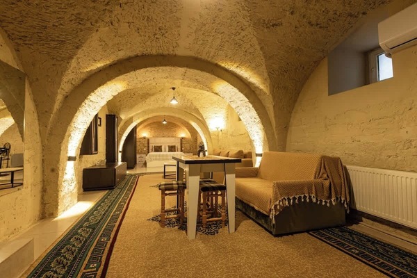 Cozy vaulted-stone suite with lounge, dining nook, and comfy bed.