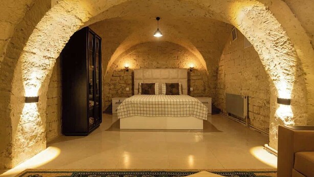 A bedroom with a large bed, a wardrobe, and a radiator.