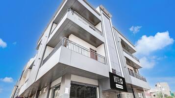 A multi-story hotel with a modern design, featuring balconies on each floor and a prominent 'HOTEL' sign.
