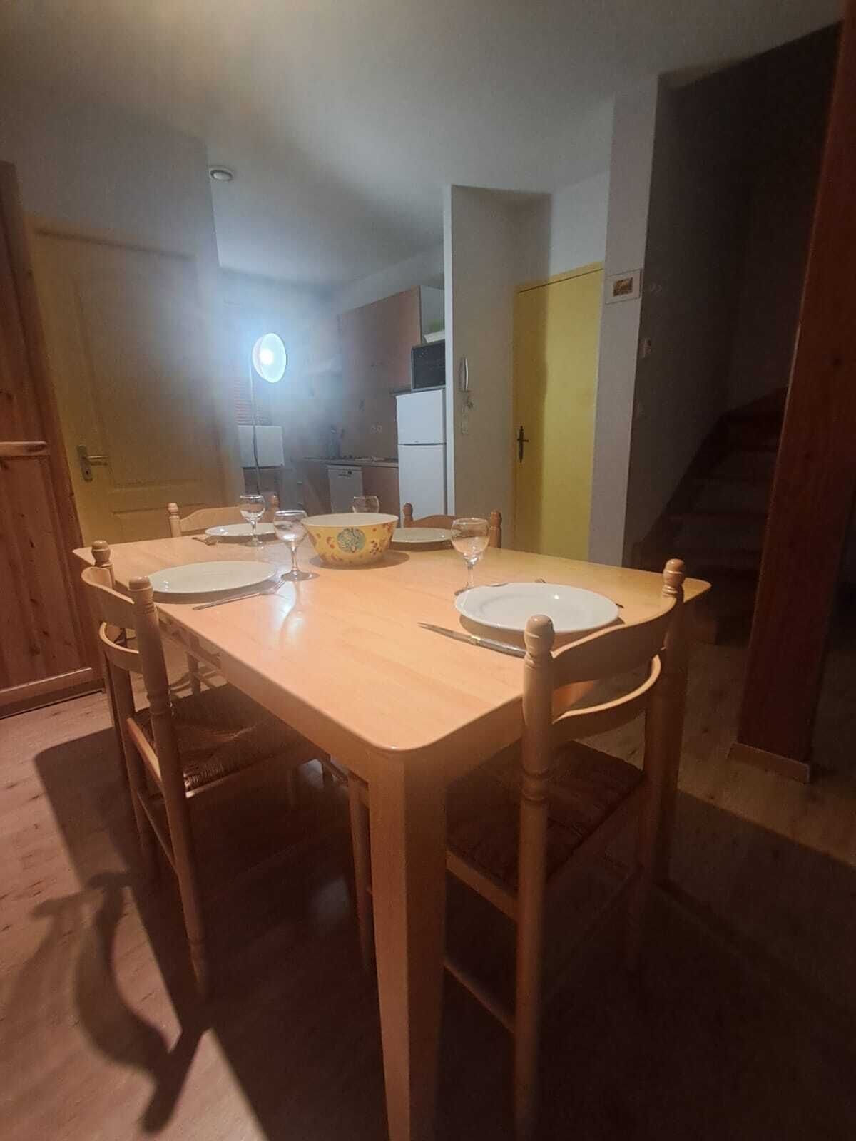 A dining table with chairs, a bowl, and wine glasses.
