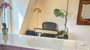 Een keuken met een inbouwoven, een hanglamp en een plant in pot.