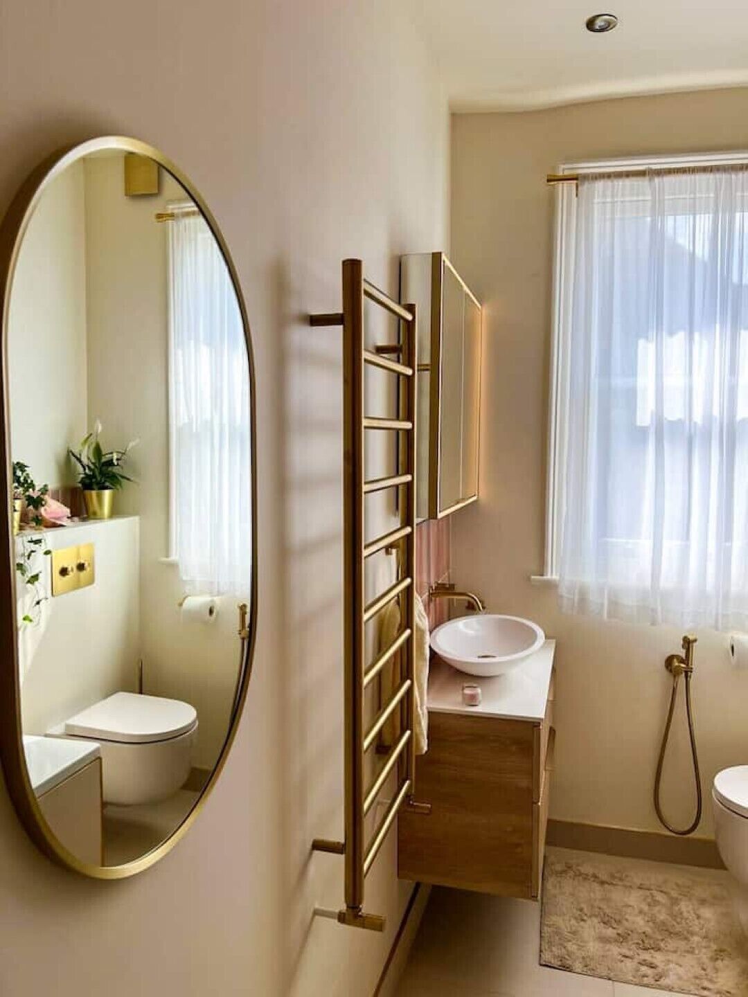 Un baño con inodoro, lavamanos y espejo.