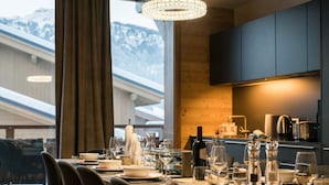 A dining table set for six with a view of mountains through large windows. - R Sidence Les Portes de Meg ve C58s (Praz-sur-Arly)