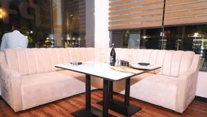 A corner seating area with a white sofa, a table, and a bottle. - Holiday Home (Ranchi)