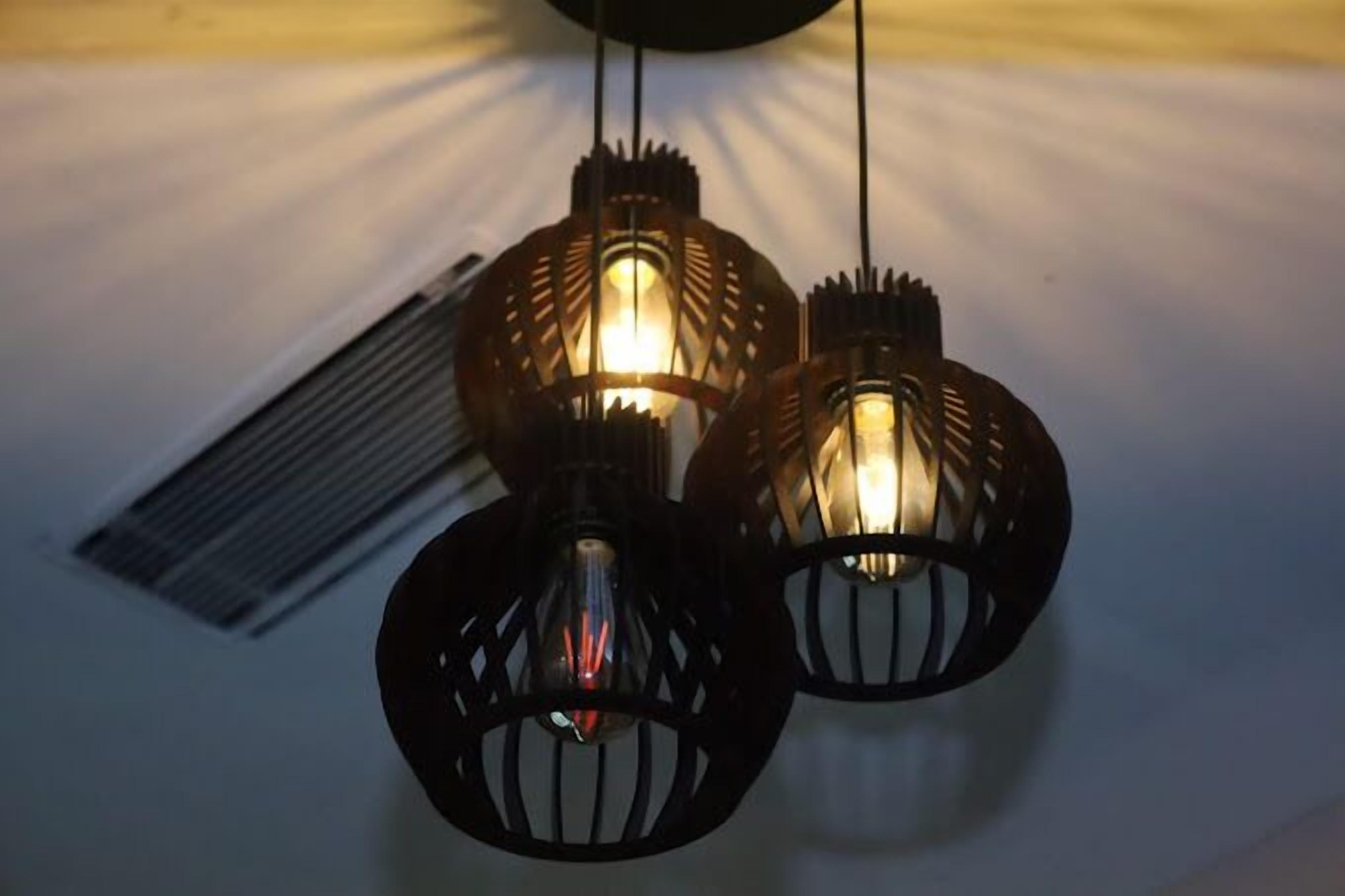 Three hanging pendant lights with a unique design.