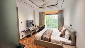 Une chambre d’hôtel moderne dotée d’un grand lit, d’un bureau, d’une télévision et d’un balcon avec vue.