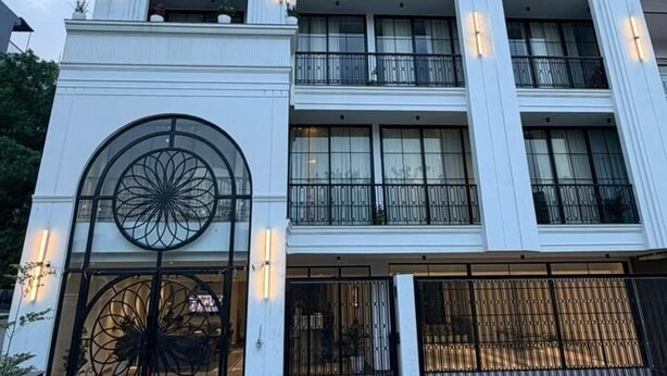 Un hôtel à plusieurs étages, doté d’une architecture classique, avec des balcons et de grandes fenêtres.