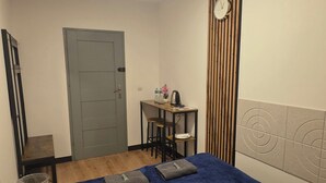 Une chambre à coucher avec un lit, un bureau, une chaise, une horloge et une porte.