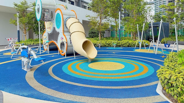 A playground with a slide and exercise equipment, surrounded by trees and buildings. - Astrum Ampang By Serenity Homes (Kuala Lumpur)