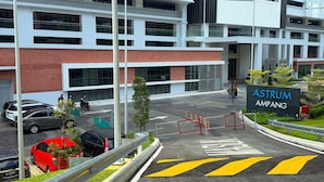 A modern building with a sign reading 'ASTRUM AMPANG' and a parking area with marked lanes. - Astrum Ampang By Serenity Homes (Kuala Lumpur)
