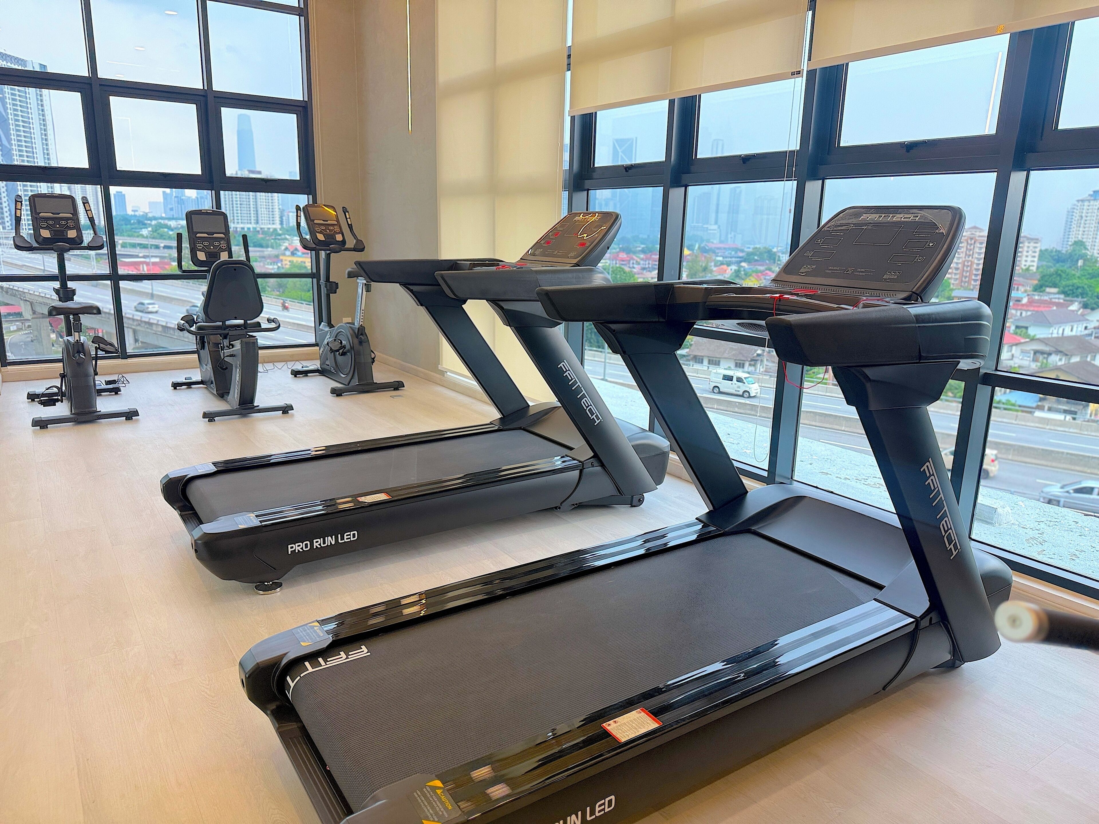 A gym with treadmills, stationary bikes, and exercise equipment.