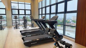 A gym with treadmills, stationary bikes, and exercise equipment.