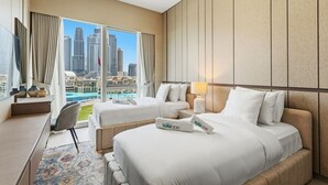 Habitación de hotel con vista a la ciudad, dos camas, un escritorio y una silla.
