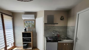 Uma cozinha compacta com lava-louças, máquina de café e escorredor de pratos.