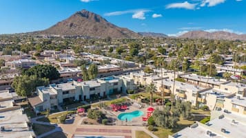 A resort with a central pool, multiple buildings, and a mountain in the background.