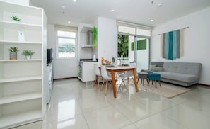 Un espacio moderno de estar con comedor, sofá y cocina.