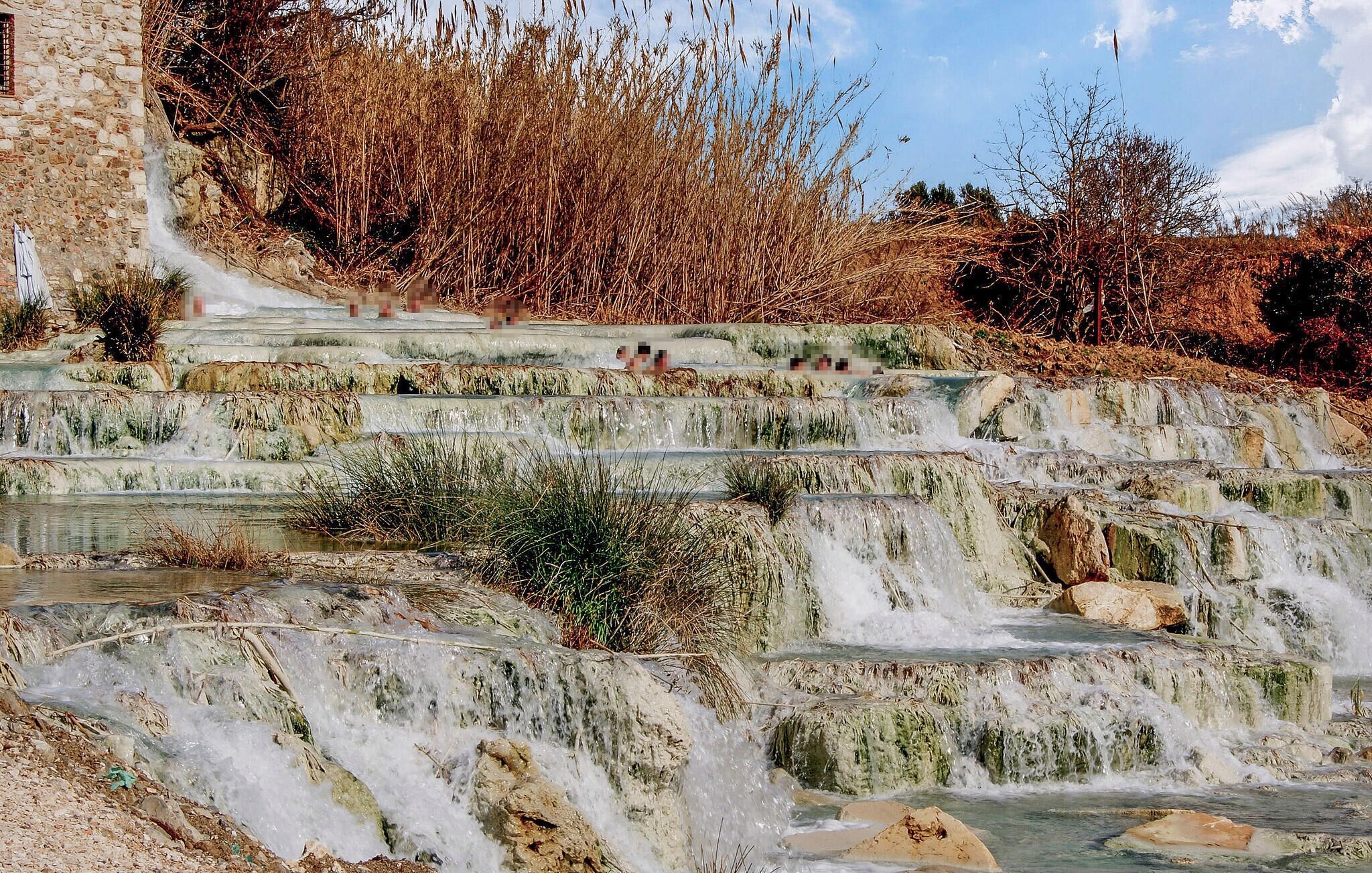 A stone staircase leading to a water feature with a clear sky above.