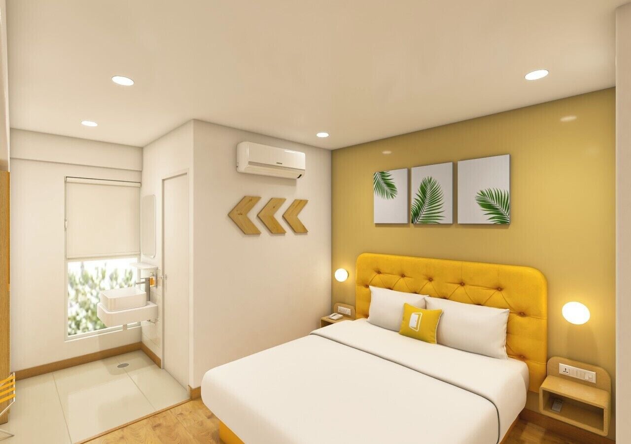 A bedroom with a bed, bedside tables, a window, an air conditioning unit, and wall-mounted artwork.