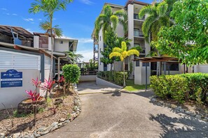 A private property with a paved pathway leading to a gated entrance, surrounded by lush greenery and palm trees. - Bluewater Hideaway—Lagoon Outlook by Trinity Beach (Trinity Beach)