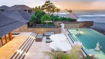 Un resort con piscina, mobiliario exterior y vistas al océano.