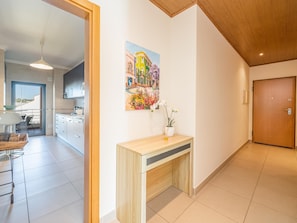 Eine moderne Küche mit weißen Schränken, einer Holzauskleidung und einem Essbereich mit Tisch und Stühlen.