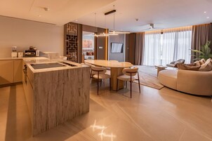 A modern living room with a marble island, a dining area, and a sofa.