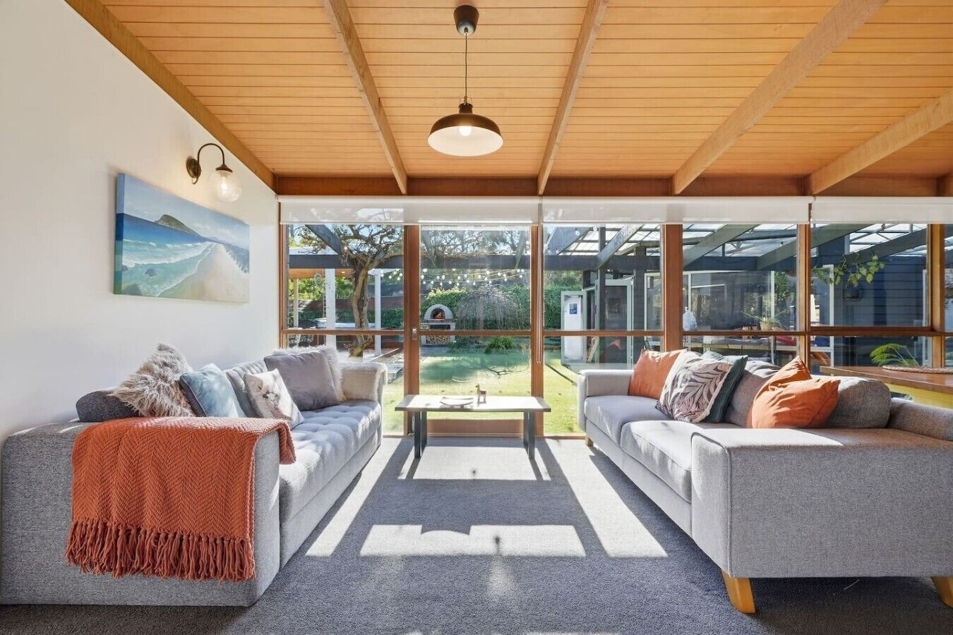 A modern living room with two sofas, a coffee table, and a large window offering a view of the outdoors.
