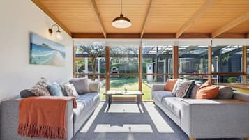 A modern living room with two sofas, a coffee table, and a large window offering a view of the outdoors.