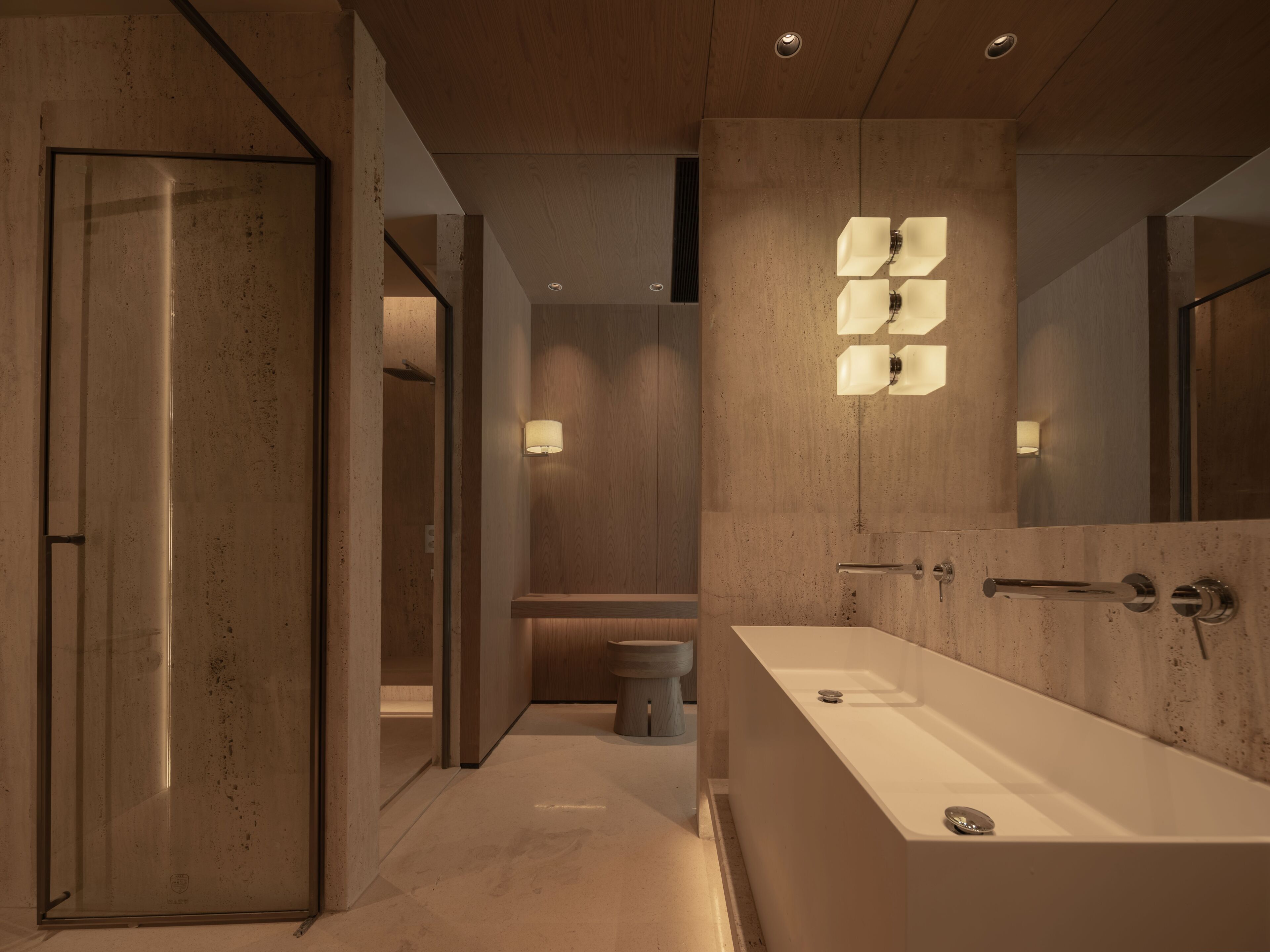Un baño moderno con una bañera grande, cabina de ducha con mampara de vidrio y tocador con espejo.