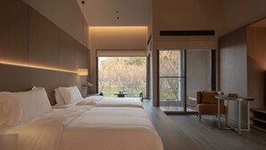 A modern hotel room with a large bed, a desk, and a view of the outdoors. - Hayama Pagoda Villa (Taizhou)