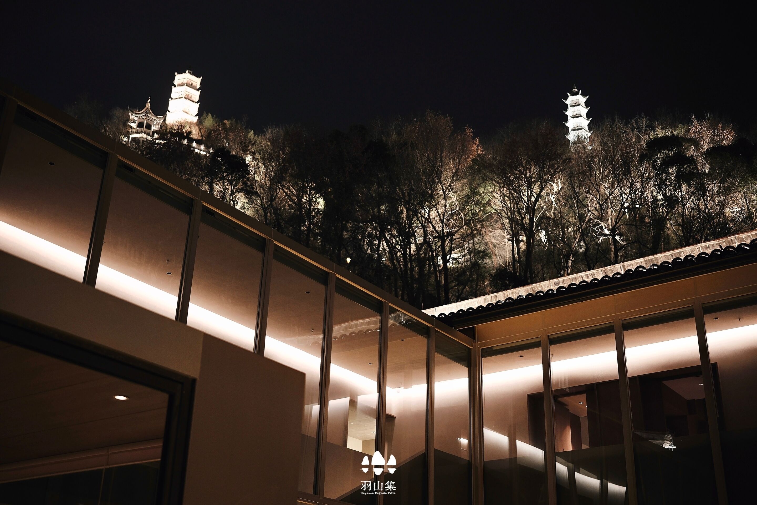 Un edificio de arquitectura tradicional, una escalera y una vista de torres de estilo pagoda al fondo.