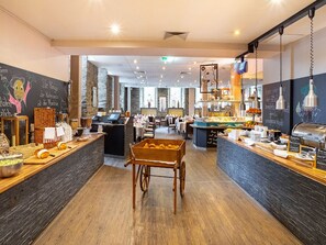 A restaurant with a central serving cart, wooden tables, and a chalkboard menu. - Relaxing Economy Triple Room | Convenient Location for Your Getaway (Köln)