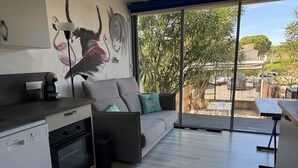 Een moderne keuken met een vaatwasser, oven en een eethoek met een tafel en stoelen.