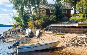 A lakeside property with a dock, two boats, and a house with a tiled roof. - Awesome home in Kinnarumma with lake view (Kinnarumma)