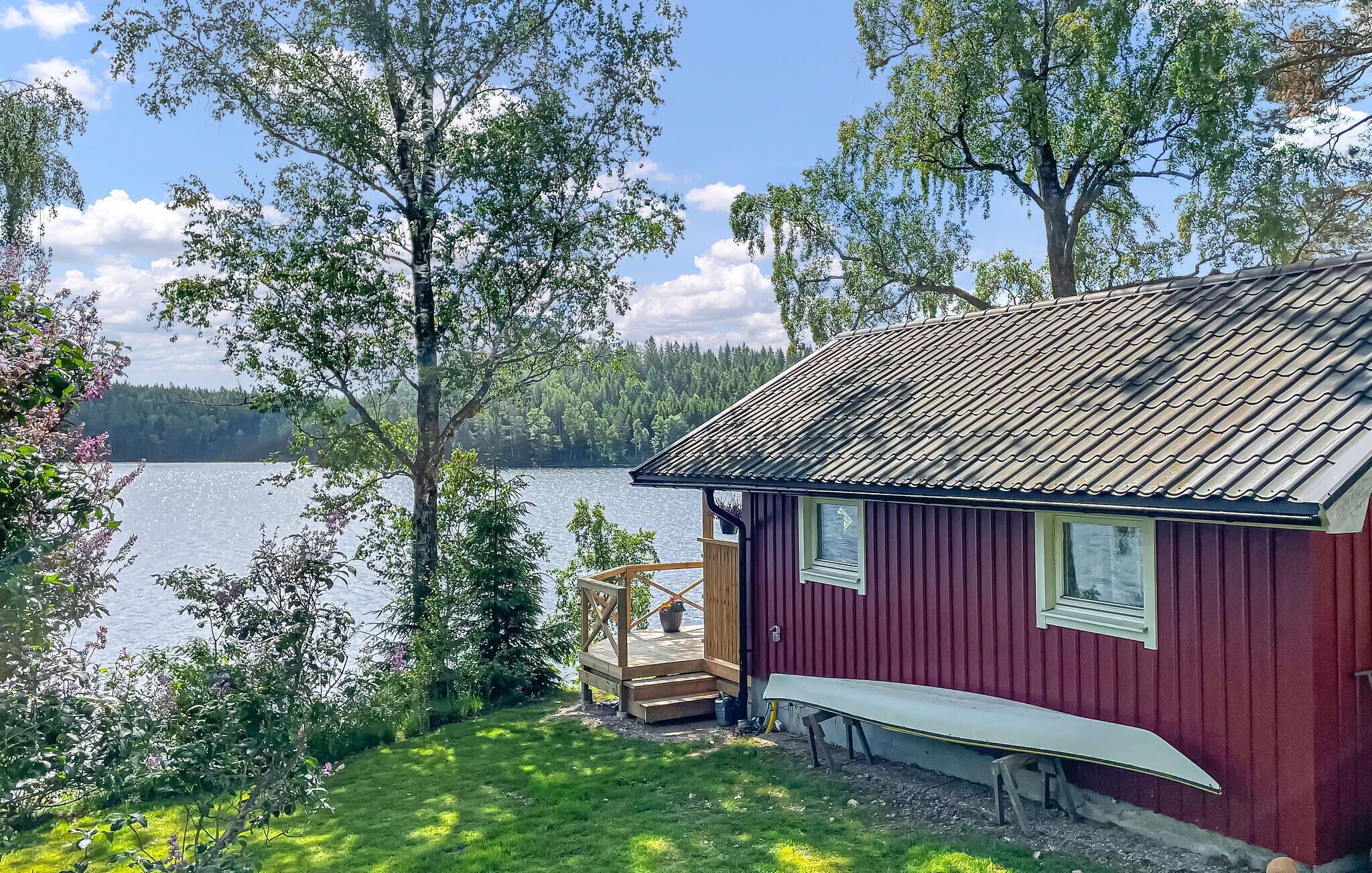 A cabin with a dock, a bench, and a view of a lake and forest.