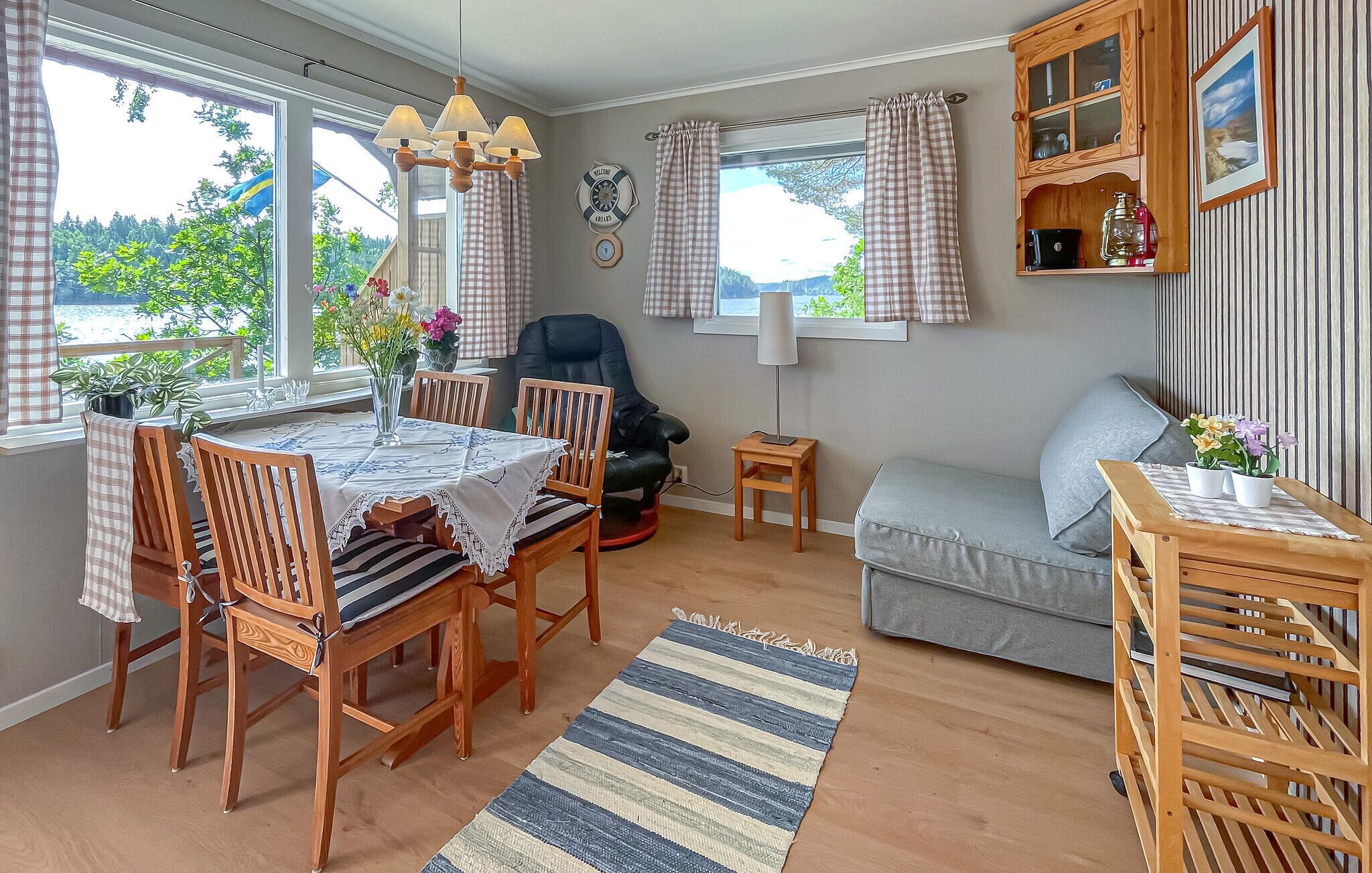 Habitació acollidora amb taula de dinar, cadirees, sofà, taula auxiliar petita i finestra amb cortines.
