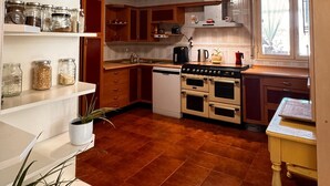 A kitchen with white shelves, a stove, and a window. - Experience the spectacle of the August 12 lunar eclipse from Garray (Soria). (Garray)