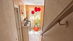 A staircase leading to a room with a window, a potted plant, and a door. - Experience the spectacle of the August 12 lunar eclipse from Garray (Soria). (Garray)