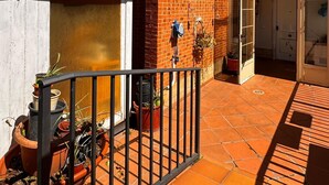 A brick house with a tiled patio, a metal gate, and potted plants. - Experience the spectacle of the August 12 lunar eclipse from Garray (Soria). (Garray)
