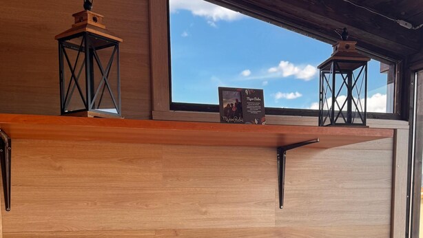 A bedroom with a wooden headboard, a window with a view, and a shelf with two lanterns. - Experience the spectacle of the August 12 lunar eclipse from Garray (Soria). (Garray)