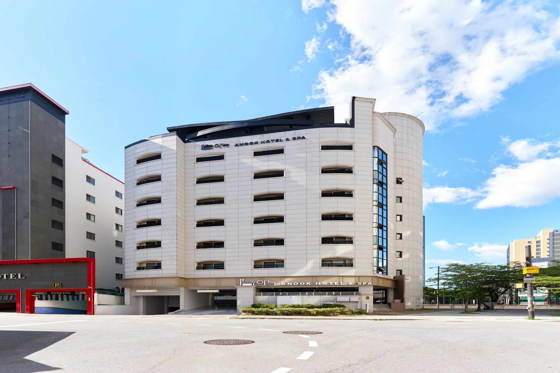 Un hotel moderno con fachada curva, varios pisos y una entrada destacada.