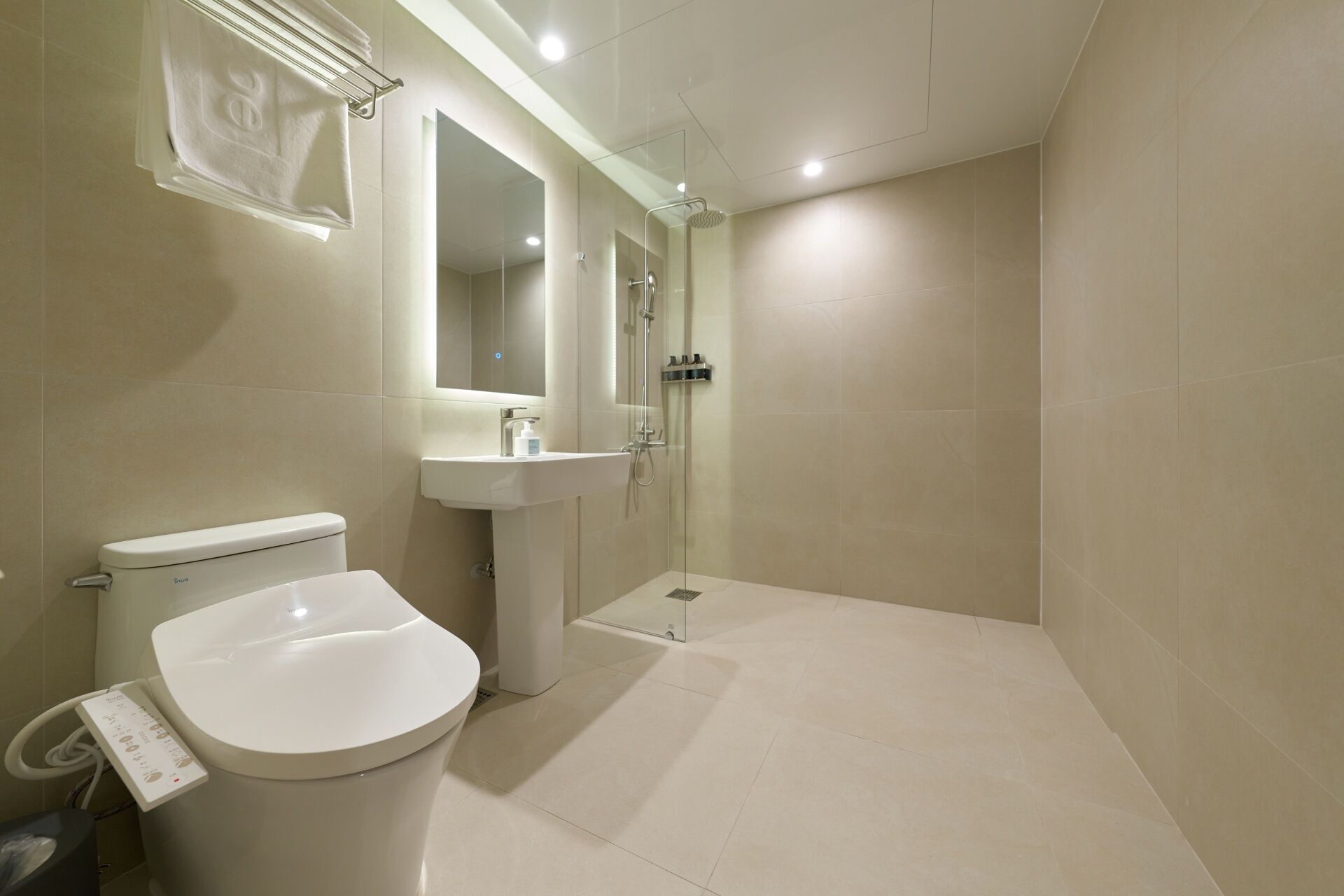 A modern bathroom with a toilet, sink, and glass-enclosed shower.