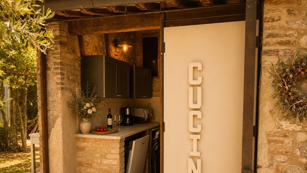 Een keuken met een stenen muur, houten kasten en een 'CUCINA' bord.