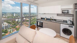 Een moderne keuken met een groot raam, een wasmachine en een eethoek met uitzicht.