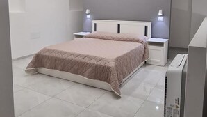 A modern bedroom with a bed, bedside tables, and a ceiling light fixture.
