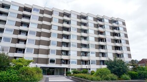 En flervåningsbostadsbyggnad med en enhetlig fasad, balkonger och en central entré.