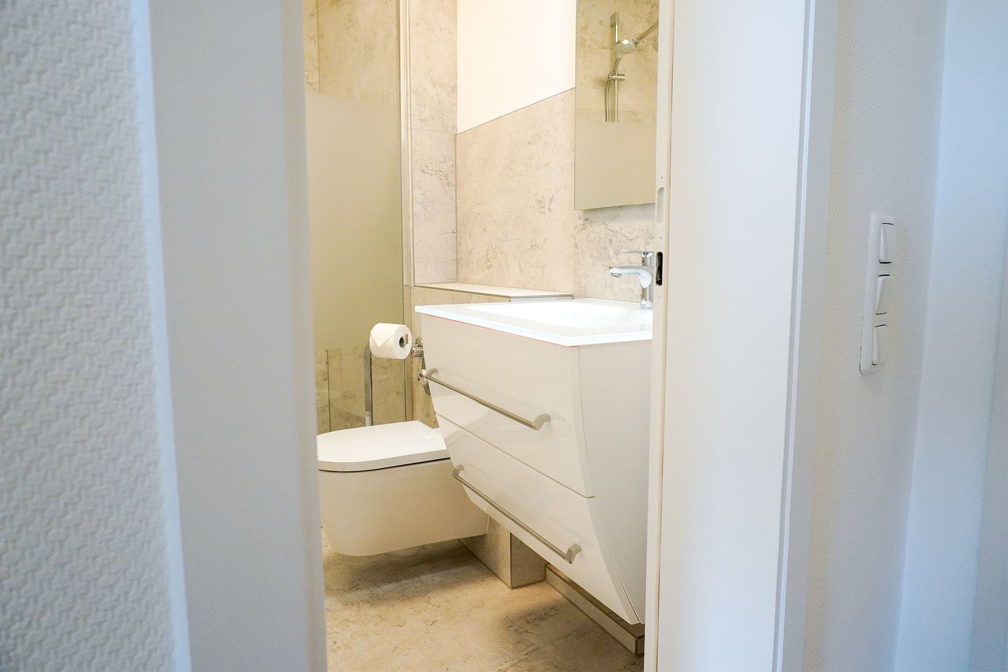 A bathroom with a toilet, a sink, and a shower.