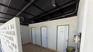 A hallway with lockers, a sink, and a hand sanitizer dispenser. - Amaya Bloom Resort & Spa (Pattaya)
