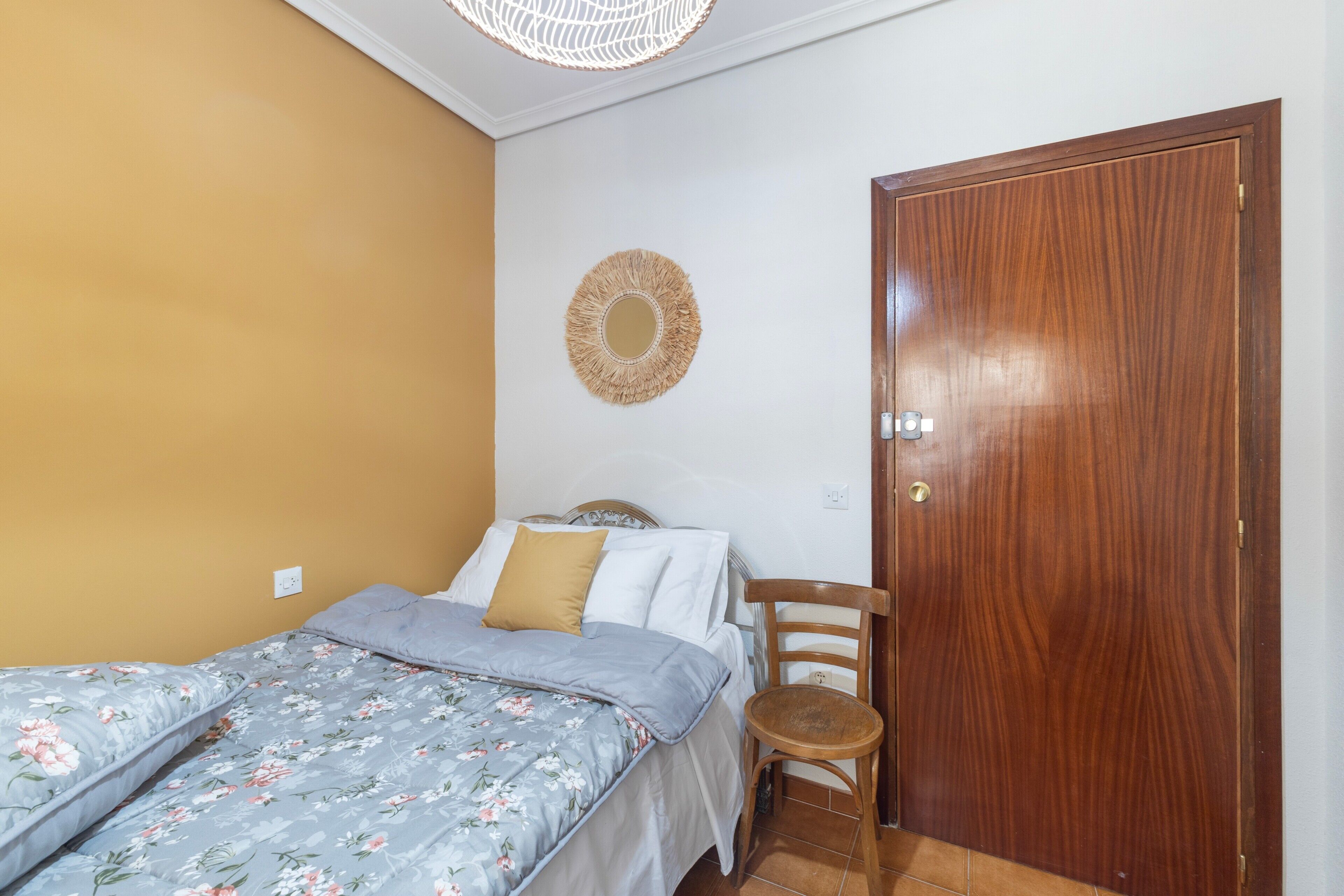 Un dormitorio con una cama, una puerta de madera y un adorno en la pared.
