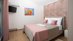A bedroom with a bed, a flat-screen TV, a painting, and a patterned wall. - Villa with private pool, summer kitchen (Šišan)